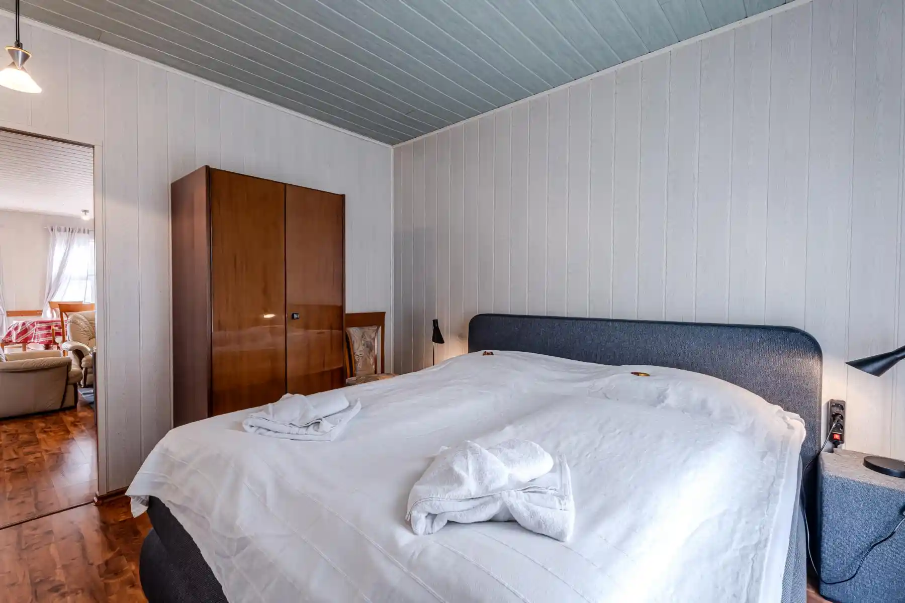Auf diesem Bild sehen Sie ein Schlafzimmer des Ferienhauses der Villa See-Eck im Seebad Ahlbeck auf der Insel Usedom von https://aufnachusedom.de. Es sind ein Boxspringbett für zwei Personen und ein Kleiderschrank zu sehen.