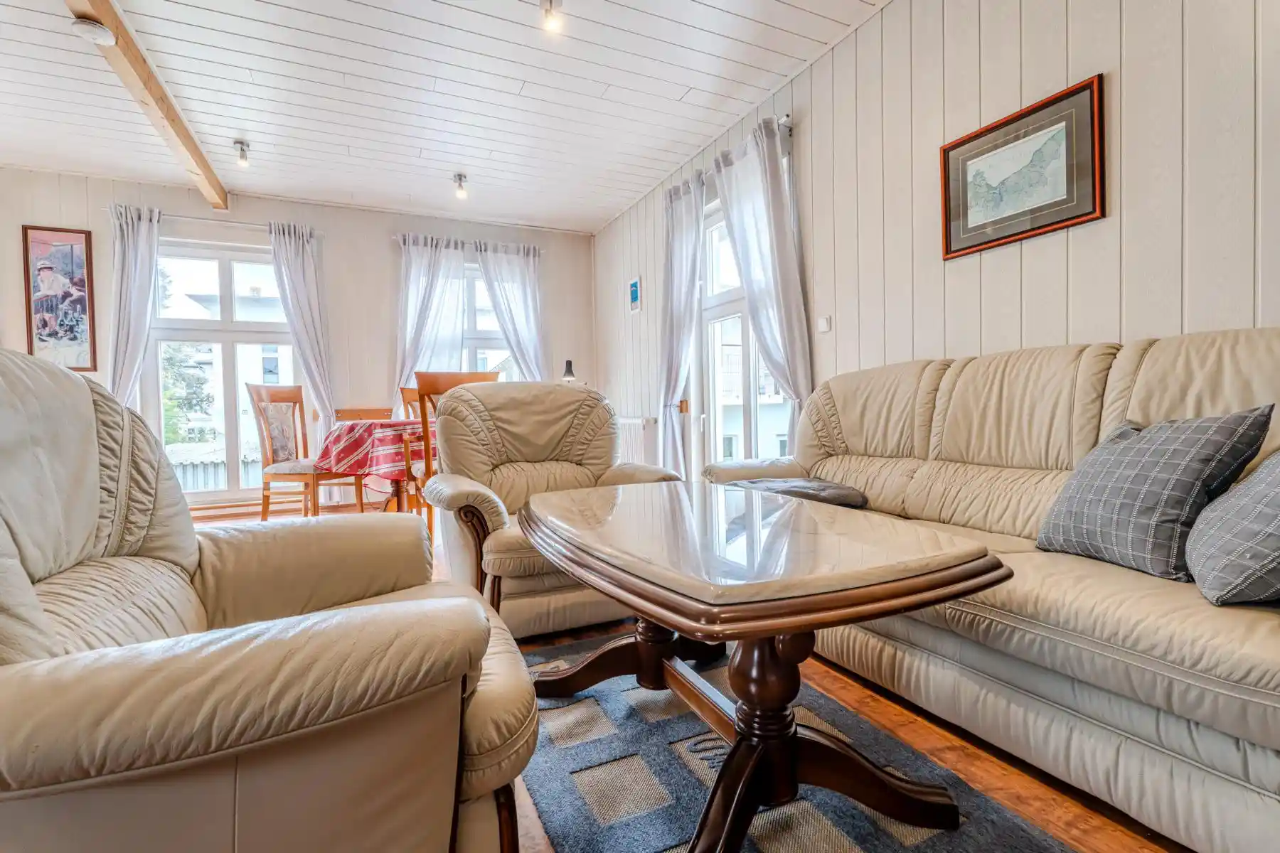 Auf diesem Bild sehen Sie das Wohnzimmer mit Esstisch, Couch-Garnitur des Ferienhauses der Villa See-Eck im Seebad Ahlbeck auf der Insel Usedom von https://aufnachusedom.de.