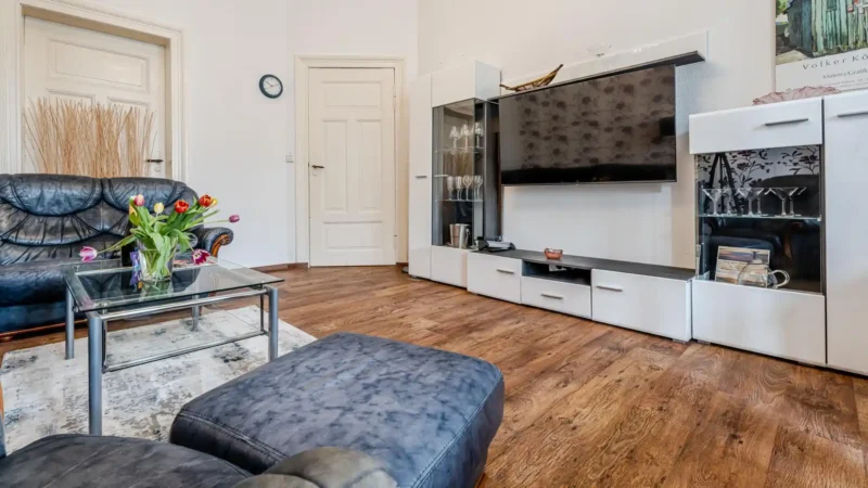 Auf diesem Bild sehen Sie das Wohnzimmer mit Couch-Garnitur, Anbauwand, Fernseher der Ferienwohnung 75 Quadratmeter im Erdgeschoss des Ferienhauses der Villa See-Eck im Seebad Ahlbeck auf der Insel Usedom von https://aufnachusedom.de.