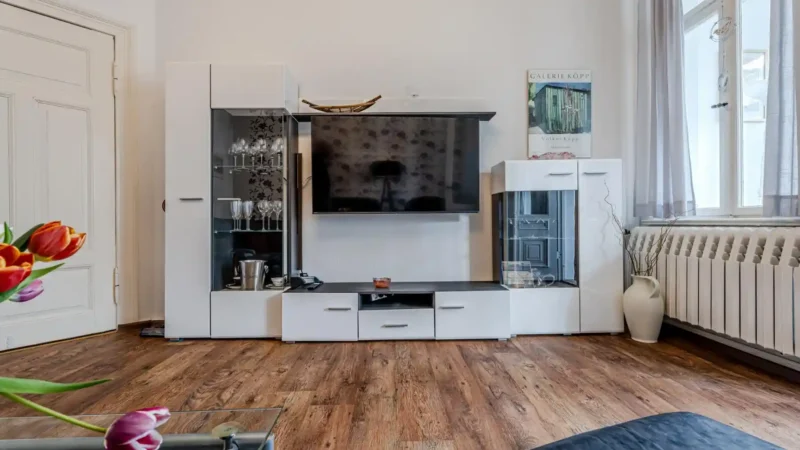 Auf diesem Bild sehen Sie das Wohnzimmer mit Anbauwand, Fernseher in der Ferienwohnung 75 Quadratmeter im Erdgeschoss des Ferienhauses der Villa See-Eck im Seebad Ahlbeck auf der Insel Usedom von https://aufnachusedom.de.