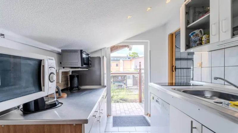 Auf diesem Bild sehen Sie die Küchenzeile mit Kühlschrank, Geschirrspüler, Mikrowelle, Mini-Backofen der Ferienwohnung Seepferdchen im ersten Obergeschoss des Gästehauses der Villa See-Eck im Seebad Ahlbeck auf der Insel Usedom von https://aufnachusedom.de.