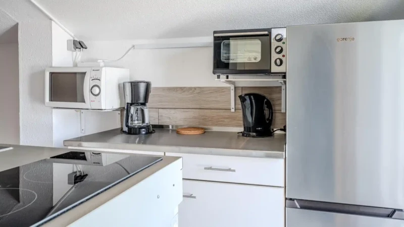 Auf diesem Bild sehen Sie die Küchenzeile mit Kühlschrank, Mikrowelle, Mini-Backofen der Ferienwohnung Seepferdchen im ersten Obergeschoss des Gästehauses der Villa See-Eck im Seebad Ahlbeck auf der Insel Usedom von https://aufnachusedom.de.